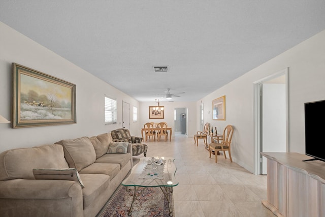 living room with ceiling fan and a textured ceiling