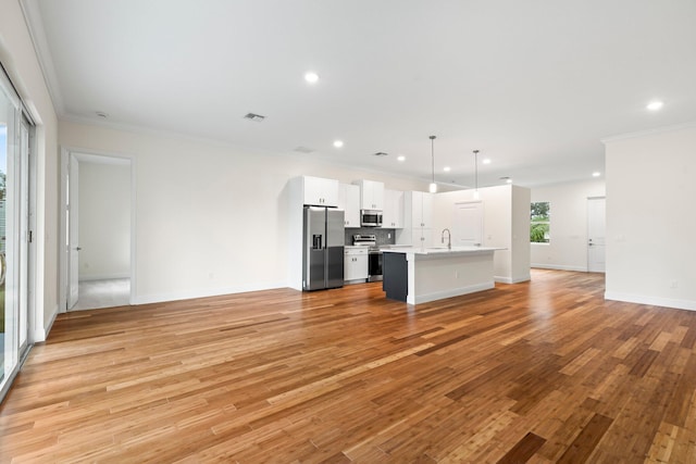 unfurnished living room with visible vents, ornamental molding, a sink, recessed lighting, and light wood finished floors