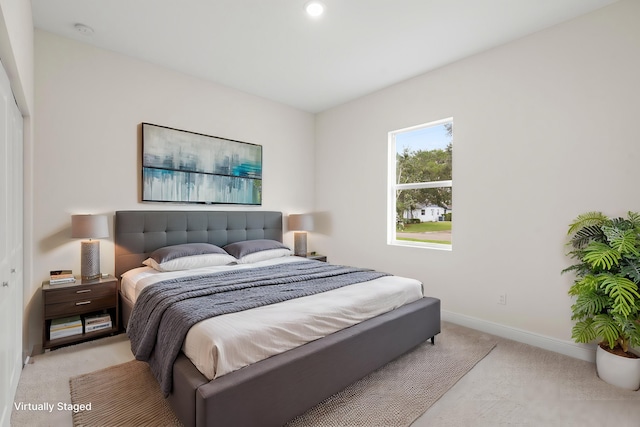 bedroom featuring light colored carpet and a closet