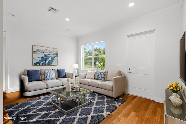 living room featuring wood finished floors, visible vents, and ornamental molding