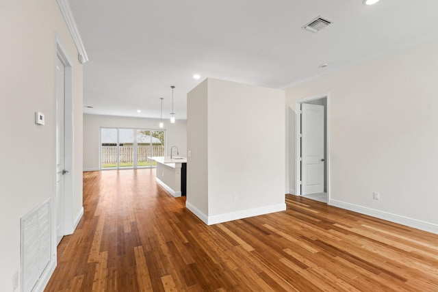 empty room featuring visible vents, recessed lighting, baseboards, and wood finished floors