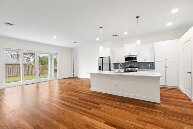 unfurnished room with sink, wood-type flooring, and ornamental molding