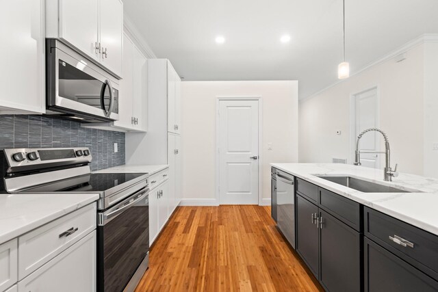 kitchen with decorative light fixtures, a center island with sink, and stainless steel appliances