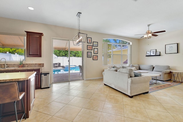 living room with sink, light tile patterned floors, and a healthy amount of sunlight