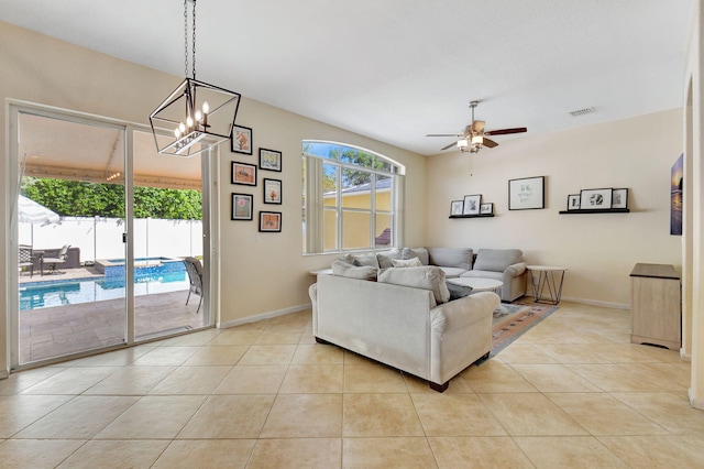 living room with ceiling fan with notable chandelier and light tile patterned flooring