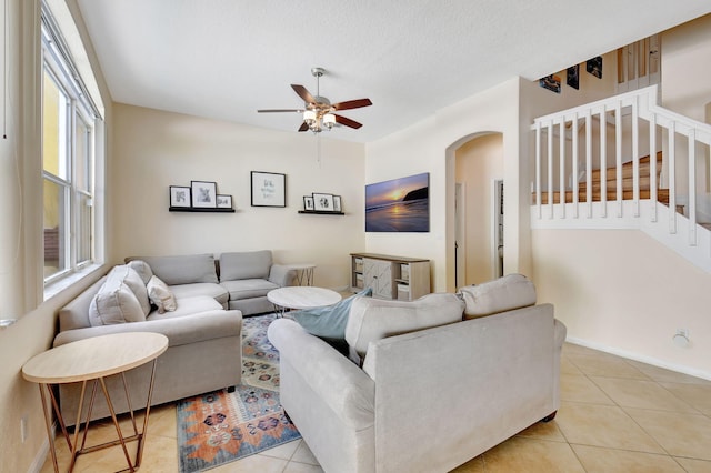 tiled living room with ceiling fan and a textured ceiling