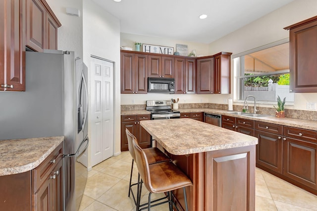 kitchen featuring sink, appliances with stainless steel finishes, light tile patterned flooring, and a kitchen island