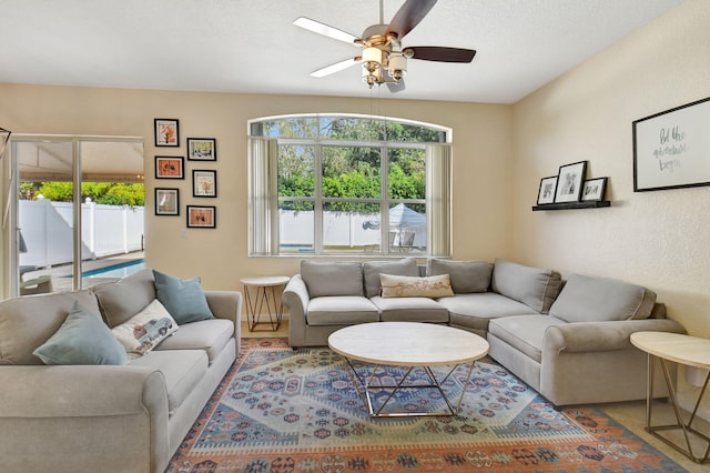 living room with ceiling fan and a textured ceiling