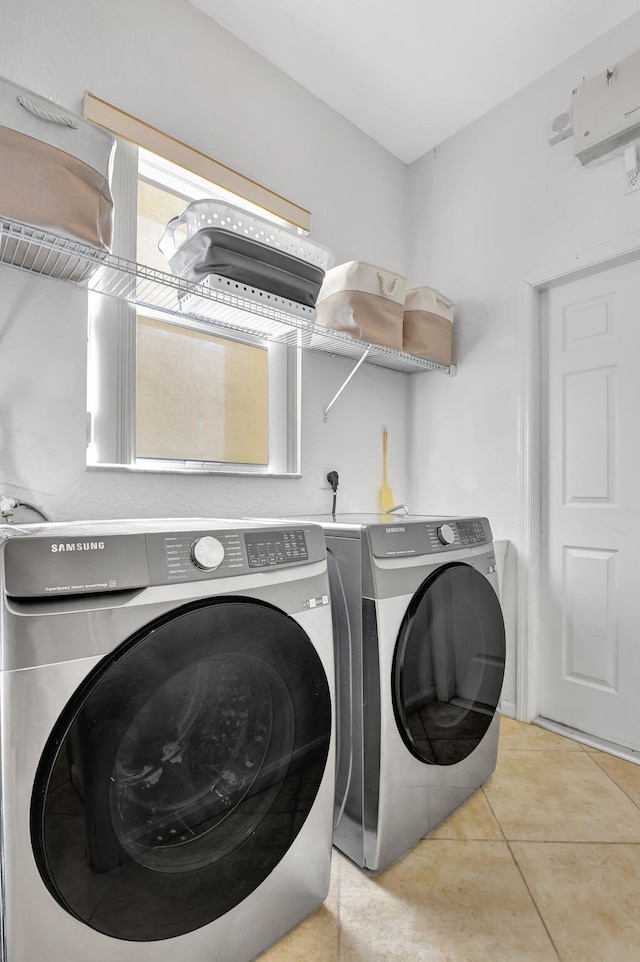 laundry room with washer and clothes dryer and light tile patterned flooring