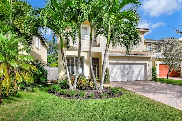 view of front facade with a balcony, a garage, and a front lawn