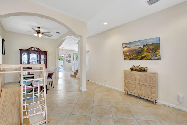 dining space with light tile patterned floors and ceiling fan with notable chandelier