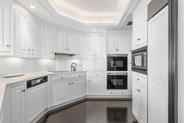 kitchen featuring black appliances, a raised ceiling, and white cabinets