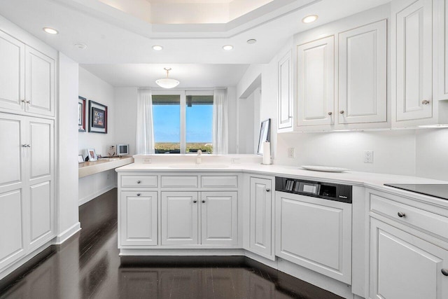 kitchen with dark hardwood / wood-style floors, white cabinetry, sink, and kitchen peninsula