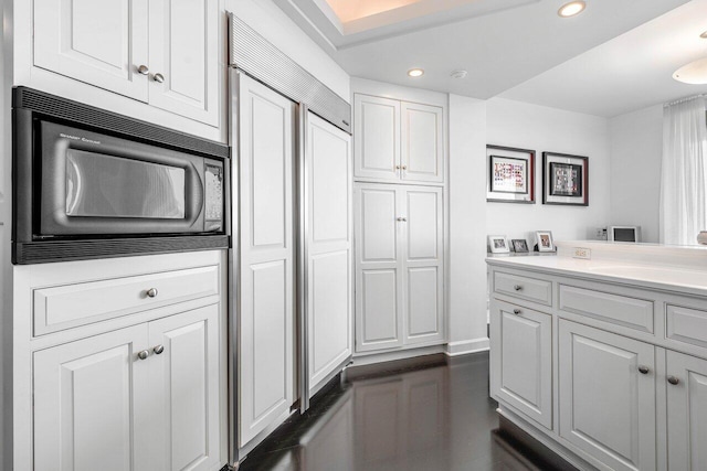 kitchen featuring white cabinetry, black microwave, and sink