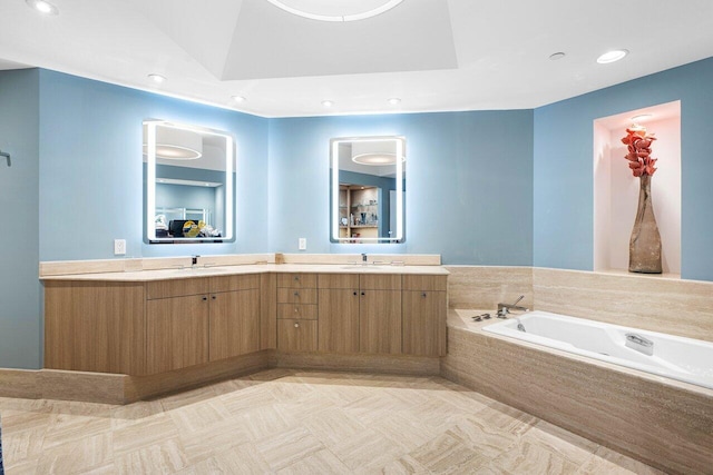 bathroom featuring vanity and tiled bath