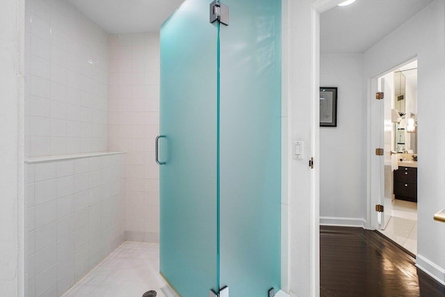 bathroom featuring wood-type flooring, vanity, and an enclosed shower