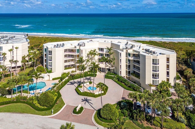 drone / aerial view featuring a water view and a view of the beach