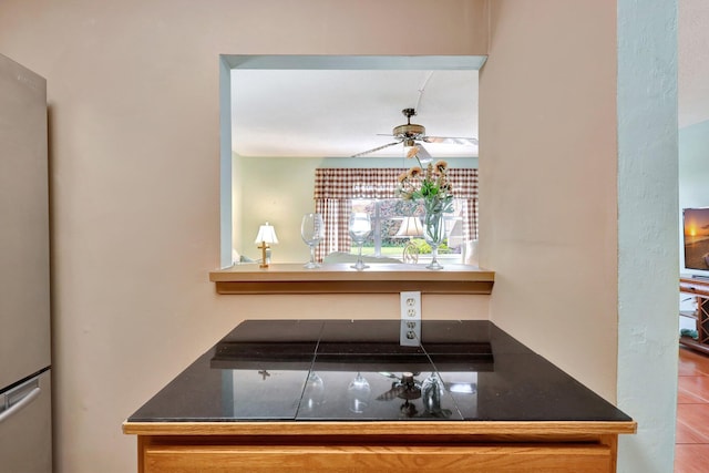 kitchen featuring ceiling fan, stainless steel fridge, and tile patterned floors