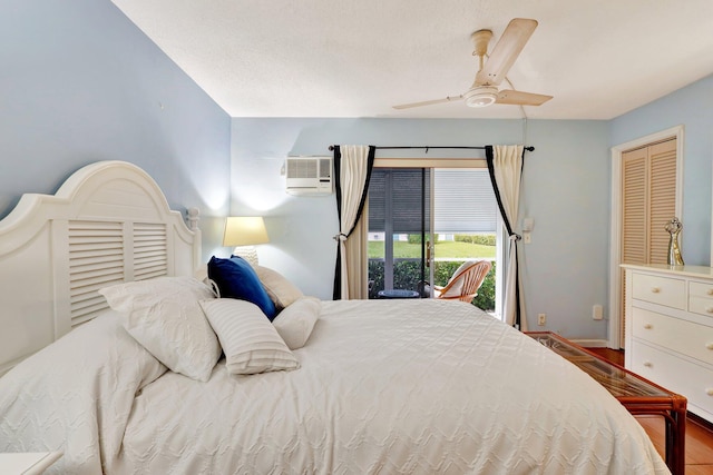 bedroom with a closet, access to exterior, hardwood / wood-style floors, a wall mounted air conditioner, and ceiling fan