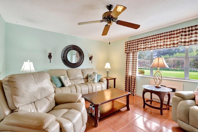 tiled living room featuring ceiling fan and a textured ceiling