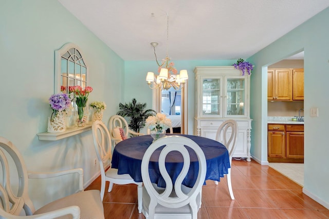 tiled dining space with sink and a notable chandelier