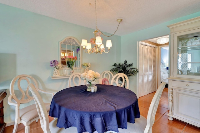 dining room featuring an inviting chandelier, light tile patterned floors, and a textured ceiling