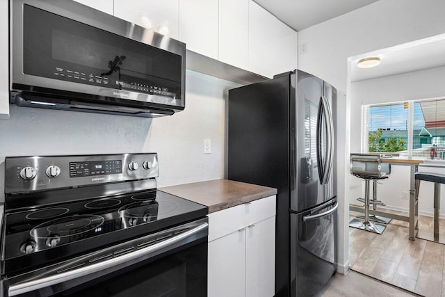 kitchen with white cabinets and appliances with stainless steel finishes