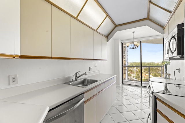 kitchen with white cabinets, hanging light fixtures, sink, vaulted ceiling, and appliances with stainless steel finishes