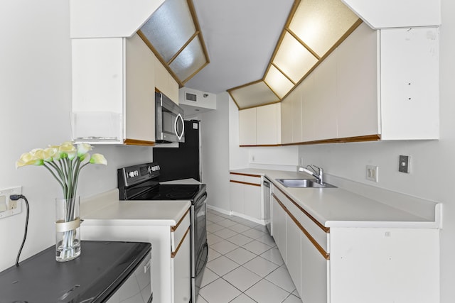 kitchen featuring sink, white cabinetry, stainless steel appliances, and light tile patterned floors