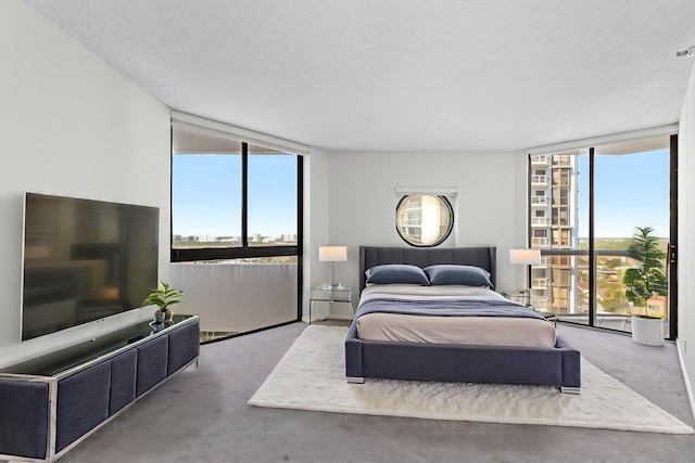 bedroom with expansive windows and concrete floors