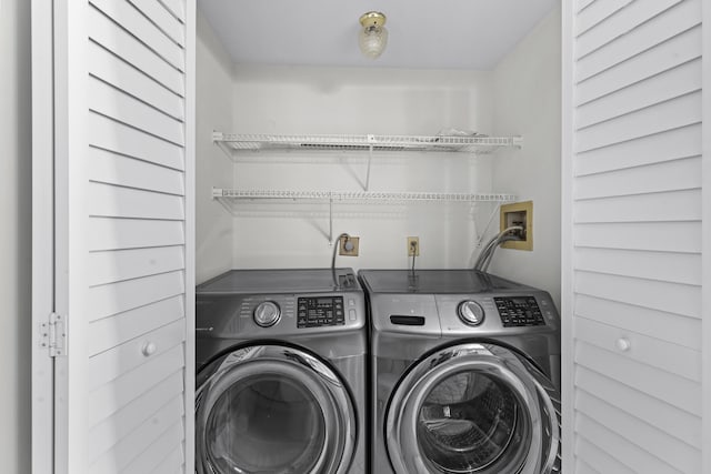 clothes washing area with washer and clothes dryer