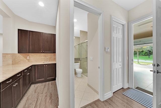 bathroom featuring decorative backsplash, an enclosed shower, vanity, wood-type flooring, and toilet