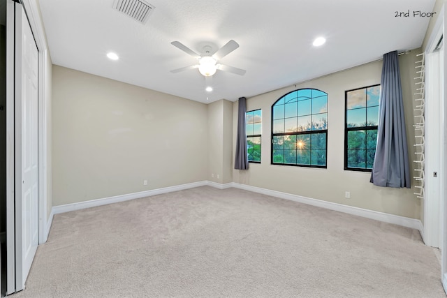 unfurnished bedroom with ceiling fan, a closet, and light carpet