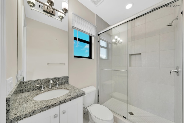 bathroom featuring vanity, an enclosed shower, and toilet