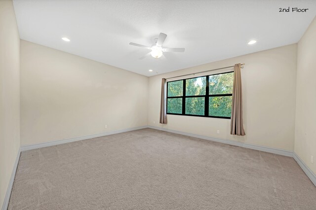 unfurnished room featuring ceiling fan and light carpet