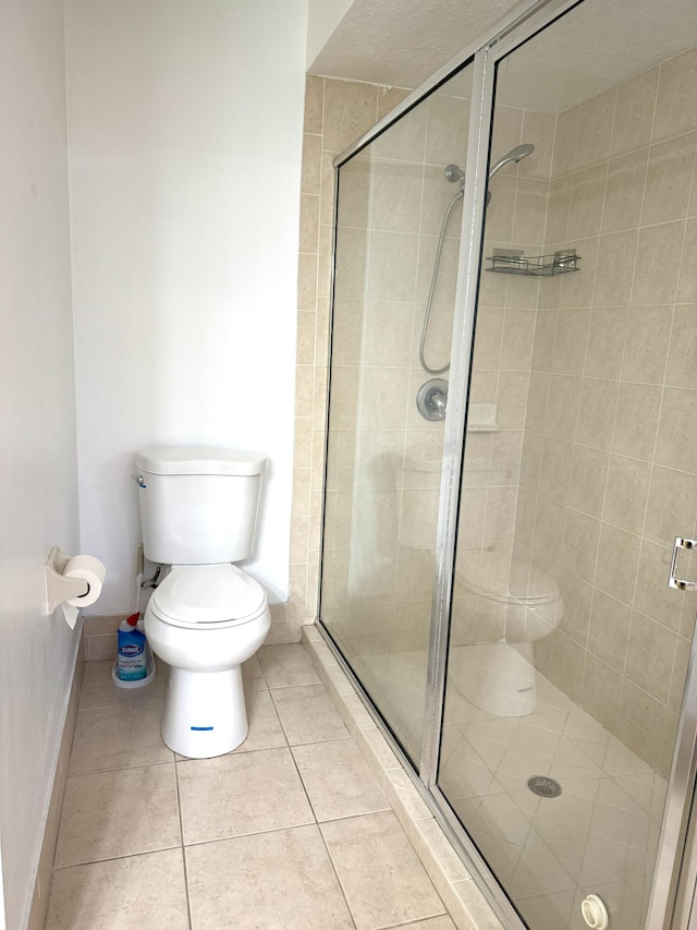 bathroom with tile patterned floors, an enclosed shower, and toilet