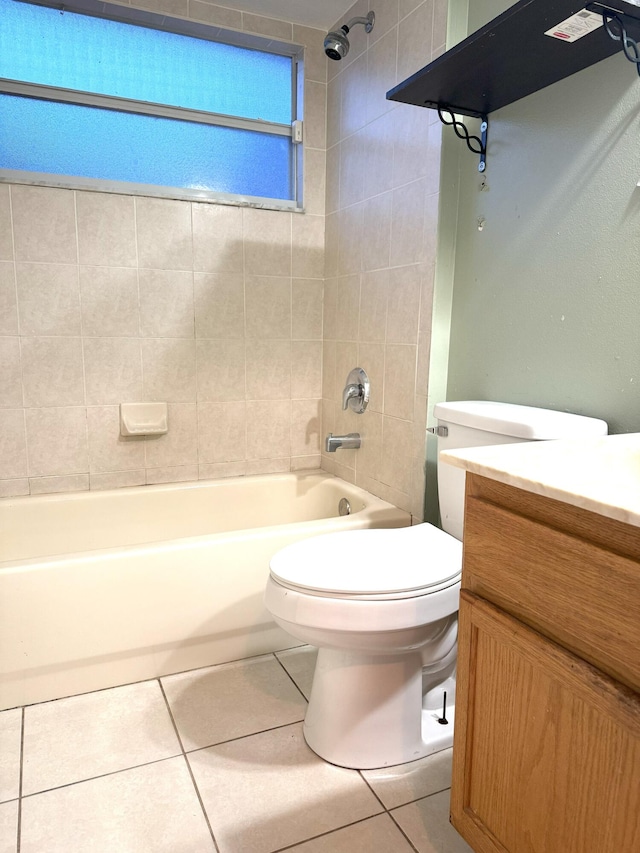 full bathroom with tile patterned floors, tiled shower / bath, vanity, and toilet