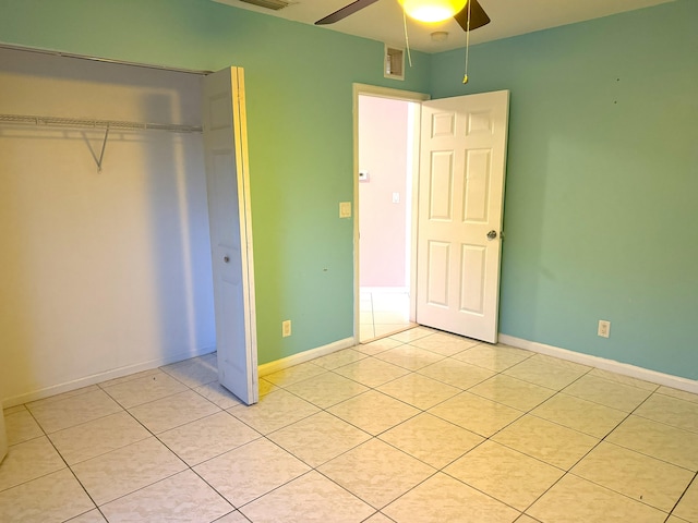 unfurnished bedroom with ceiling fan, a closet, and light tile patterned floors