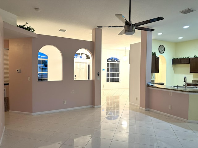 interior space with ceiling fan, sink, and light tile patterned floors