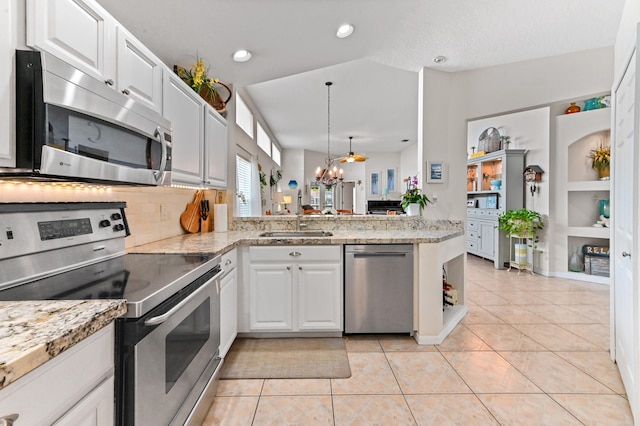 kitchen with kitchen peninsula, white cabinetry, stainless steel appliances, and light tile patterned floors