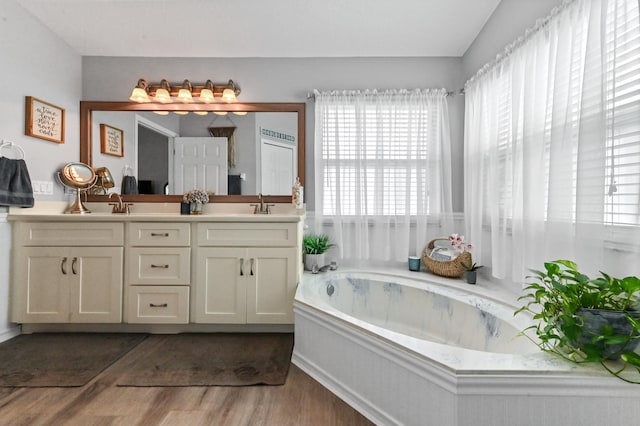 bathroom featuring hardwood / wood-style floors, vanity, a bath, and vaulted ceiling