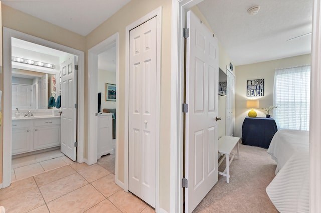 corridor with light colored carpet and sink