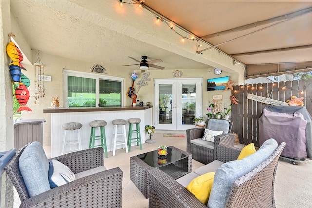 view of patio / terrace featuring a bar, an outdoor living space, french doors, and ceiling fan