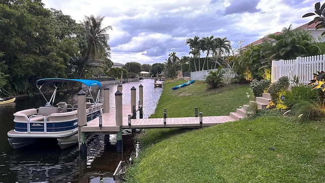 dock area with a yard and a water view