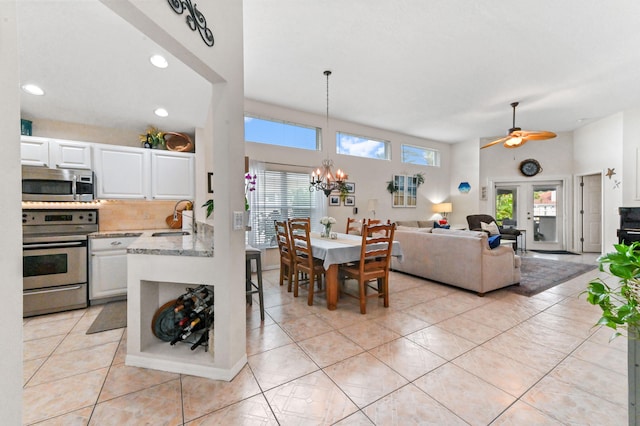 kitchen with white cabinets, decorative light fixtures, stainless steel appliances, and sink