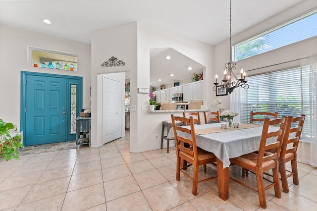 tiled dining space featuring a chandelier and a high ceiling