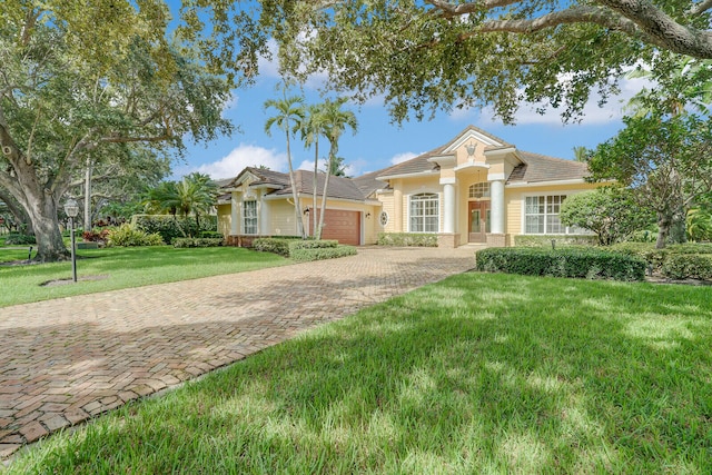 view of front of property featuring a front yard and a garage