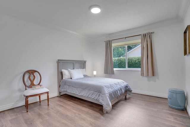 bedroom with hardwood / wood-style flooring and ornamental molding