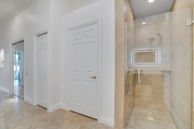 bathroom with an enclosed shower and crown molding