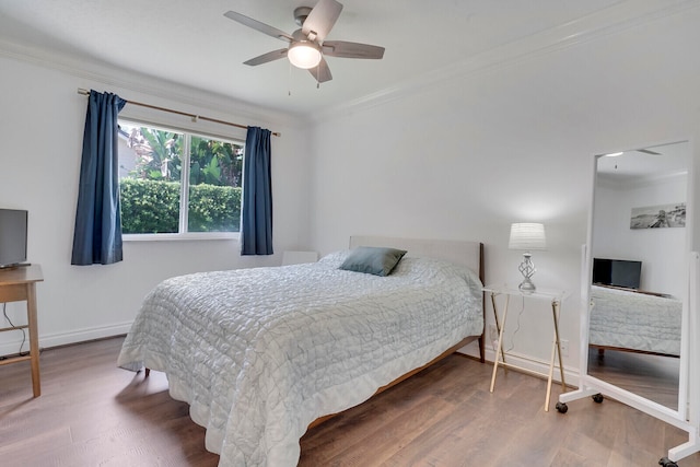 bedroom with ceiling fan, ornamental molding, and hardwood / wood-style flooring